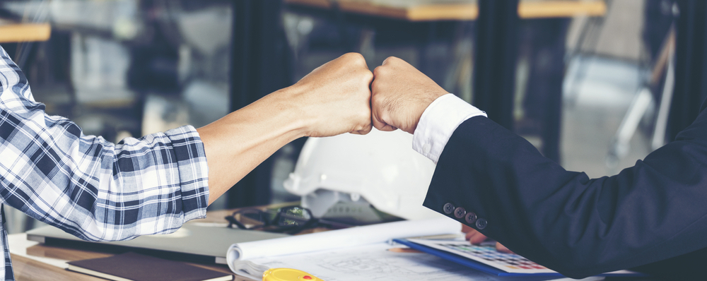 Coworkers Fist Bumping in Office
